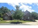 Charming brick home featuring a lush green lawn, beautiful landscaping, and a peaceful residential setting at 323 Wendover Dr, Locust, NC 28097
