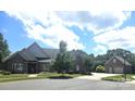 Lovely brick home with detached garage, lush landscaping, and a serene suburban view at 323 Wendover Dr, Locust, NC 28097