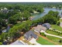 Breathtaking aerial shot of a home nestled by a serene lake, surrounded by trees, showcases its idyllic setting at 4069 Rivendell Rd, Denver, NC 28037