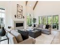 Bright living room boasts high ceilings, wooden beams, fireplace, and sliding glass doors to the deck at 4069 Rivendell Rd, Denver, NC 28037