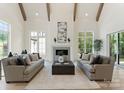 Bright living room features high ceilings, wooden beams, fireplace, and two plush sofas at 4069 Rivendell Rd, Denver, NC 28037