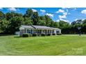 Charming brick home with a well-manicured lawn, mature trees, and ample driveway space at 50 Isenhour Park Rd, Taylorsville, NC 28681
