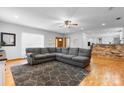 Open-concept living room with a large sectional couch, wood floors, and a brick accent wall in the kitchen at 50 Isenhour Park Rd, Taylorsville, NC 28681