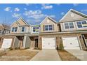 Charming townhomes with stone accents, attached garages, and well-manicured lawns offer modern living at 6274 Tea Olive Dr # 237, Harrisburg, NC 28075