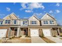 Charming townhomes with stone accents, attached garages, and well-manicured lawns offer modern living at 6274 Tea Olive Dr # 237, Harrisburg, NC 28075