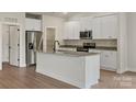 Modern kitchen with white cabinets, granite countertops, stainless steel appliances, and a center island at 7106 Jerimoth Dr, Charlotte, NC 28215