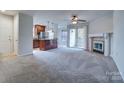 Open-concept living room flows into the kitchen, featuring a fireplace and sliding glass door at 8115 Tremaine Ct, Charlotte, NC 28227