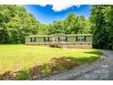 Single-story home with front-facing porch and yard, framed by mature trees on a sunny day at 812 Acclaim Dr, York, SC 29745