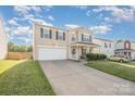 A charming two-story home featuring an attached garage and a front lawn under a partly cloudy sky at 9822 Bayview Pkwy, Charlotte, NC 28216