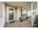Inviting front porch with seating area, window with shutters, and a decorative potted plant at 9822 Bayview Pkwy, Charlotte, NC 28216
