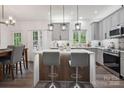 Stylish kitchen featuring a large island with seating and modern pendant lighting at 9954 Mitchell Glen Dr, Charlotte, NC 28277