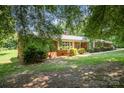 A beautiful, one-story brick home boasts a well-maintained yard and is framed by mature trees at 114 Huffstetler Rd, Gastonia, NC 28056