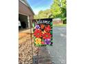 Welcome guests with this vibrant floral flag next to the brick-lined driveway at 114 Huffstetler Rd, Gastonia, NC 28056