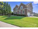 Lovely brick home with an attached garage and a well-maintained lawn at 12004 New Bond Dr, Huntersville, NC 28078