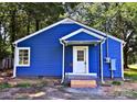 Exterior shot of blue cottage-style home with crisp white trim, showcasing charming curb appeal at 218 Hartman St, Gastonia, NC 28052