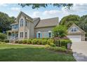 Well-maintained house features blue shutters, a lush lawn, and a detached garage with matching architectural details at 2256 Drawbridge Ct, Rock Hill, SC 29732