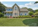 Charming two-story home with blue shutters, covered porch, and manicured lawn under a sunny blue sky at 2256 Drawbridge Ct, Rock Hill, SC 29732