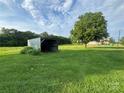 Open-sided shed sits in a spacious yard with scattered trees and a distant house at 22987 Alonzo Rd, Oakboro, NC 28129