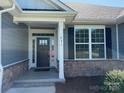 Inviting front entrance featuring a black door, sidelights, and elegant stone accents for added curb appeal at 231 Glenwood Dr # 4, Oakboro, NC 28129