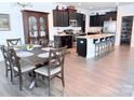 Open-concept kitchen and dining area with wood floors, dark cabinets, and a granite island at 231 Glenwood Dr # 4, Oakboro, NC 28129