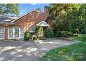 Brick home with well-manicured landscaping and a walkway leading to a private entrance at 307 Dogwood Dr, Mount Holly, NC 28120