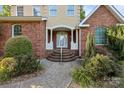 Elegant front entrance with a brick facade, white columns, and a neatly landscaped walkway at 322 Oakview Dr, Salisbury, NC 28146