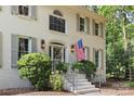 Close up of the home's entrance with an American flag, white stairs and iron railing and mature landscaping at 3717 Bounty Ct, Matthews, NC 28104