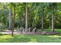 Inviting outdoor seating area featuring an arrangement of chairs in a wooded setting with ambient string lights at 3717 Bounty Ct, Matthews, NC 28104