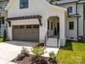 Modern farmhouse style home with gray garage, with landscaping around the walkway to the front door at 3953 Plainview Rd, Charlotte, NC 28208
