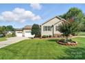 Beautiful home showcasing an attached three-car garage, and a neatly maintained lawn at 402 Walnut St, China Grove, NC 28023
