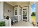 Inviting front porch with neutral colors, comfortable chair, and decorative wreath on the front door at 4079 Murray St, Fort Mill, SC 29707