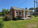 Quaint brick home with a covered front porch and manicured lawn at 412 Ridge St, Stanley, NC 28164