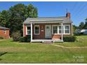 Well-kept brick home featuring a covered porch and manicured lawn at 412 Ridge St, Stanley, NC 28164