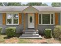 Close-up of the front door and facade with wood shutters and stone steps at 435 Stirewalt Rd, China Grove, NC 28023