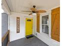 Cozy front porch with wood-look ceiling fan, shutters, and a cheerful yellow door at 435 Stirewalt Rd, China Grove, NC 28023