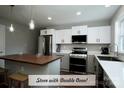 Well-lit kitchen with modern stainless steel appliances, white and gray cabinets, and a kitchen island at 4429 Dawnwood Dr, Gastonia, NC 28056