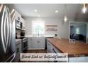 Stylish kitchen featuring stainless steel appliances, floating wood shelves, and a large sink at 4429 Dawnwood Dr, Gastonia, NC 28056