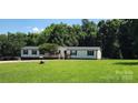 Single-story home with well and charming front porch amidst a lush, green lawn at 4688 Taxahaw Rd, Lancaster, SC 29720