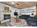 Inviting living room with a stone fireplace, ceiling fan, and wood-look flooring at 5083 Fleetwood Dr, Hickory, NC 28602
