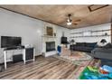 Inviting living room with a stone fireplace, ceiling fan, and wood-look flooring at 5083 Fleetwood Dr, Hickory, NC 28602