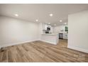 Open concept living space with wood-look floors and views into the kitchen with a white breakfast bar at 517 Dutch Ave, Mount Holly, NC 28120