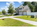 Inviting two-story home with a two-car garage, well-manicured lawn, and a white picket fence at 523 Smokehouse Ln, Albemarle, NC 28001