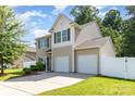 Charming two-story home featuring a two-car garage, well-maintained lawn and a white picket fence at 523 Smokehouse Ln, Albemarle, NC 28001
