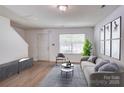 Staged living room boasting wood-look flooring, neutral tones, and stylish decor for a modern appeal at 5319 Swearngan Rd, Charlotte, NC 28216