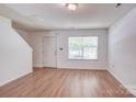 Inviting living room with wood-look flooring and ample natural light from a large window at 5319 Swearngan Rd, Charlotte, NC 28216