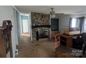 Living room featuring a stone fireplace, ceiling fan, and vintage built-ins at 5324 Weblee Ct, Kings Mountain, NC 28086