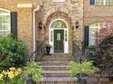 Charming brick home entrance, featuring a stone archway, manicured landscaping, and wrought iron railings at 5955 Mountain Point Ln, Charlotte, NC 28216