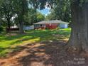 Large backyard with a deck perfect for outdoor entertaining, lush grass, and shady trees at 6109 Cora St, Charlotte, NC 28216
