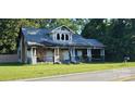 Home with damaged facade, covered front porch, and trees in the background at 619 N Main St, Landis, NC 28088