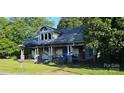 Two-story home with damaged facade, covered front porch, and blue front door at 619 N Main St, Landis, NC 28088